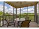 Relaxing screened-in patio with table and chairs, perfect for enjoying the outdoors and overlooking lush greenery at 9055 Treasure Trove Ln # 409, Kissimmee, FL 34747