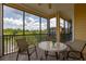 Inviting screened patio with a table and chairs offering a serene view of the building exterior and landscaping at 9055 Treasure Trove Ln # 409, Kissimmee, FL 34747