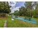 Outdoor recreation area with picnic tables, barbeque grill and a cornhole game in a well landscaped area at 9055 Treasure Trove Ln # 409, Kissimmee, FL 34747