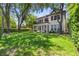 Beautifully landscaped backyard featuring a spacious lawn, mature trees, and manicured hedges for serene outdoor living at 9799 Covent Garden Dr, Orlando, FL 32827