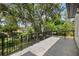 Expansive balcony with black metal railing offers serene views of lush greenery and mature trees at 9799 Covent Garden Dr, Orlando, FL 32827