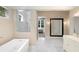 Bright bathroom featuring a large soaking tub, walk-in shower, and marble floors at 9799 Covent Garden Dr, Orlando, FL 32827