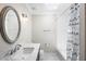 Bathroom featuring a marble countertop, oval mirror, and shower/tub with white and blue shower curtain at 9799 Covent Garden Dr, Orlando, FL 32827