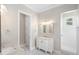 Elegant bathroom featuring double vanities, marble countertops, modern lighting, and a separate shower area at 9799 Covent Garden Dr, Orlando, FL 32827