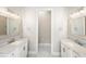 Bright bathroom featuring dual vanities, marble countertops, and modern fixtures with a doorway leading to the toilet at 9799 Covent Garden Dr, Orlando, FL 32827