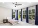 Cozy bedroom with blue curtains, ample natural light from multiple windows, and a ceiling fan at 9799 Covent Garden Dr, Orlando, FL 32827