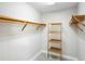 Walk-in closet with multiple wood shelving units for storage and organization of clothes and accessories at 9799 Covent Garden Dr, Orlando, FL 32827