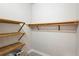 Walk-in closet with multiple wood shelving units for storage and organization of clothes and accessories at 9799 Covent Garden Dr, Orlando, FL 32827