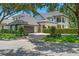 Charming two-story house featuring a gray roof, balcony, meticulously landscaped grounds, and brick driveway at 9799 Covent Garden Dr, Orlando, FL 32827