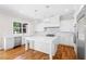 A modern white kitchen featuring an island, stainless steel appliances, and marble countertops and backsplash at 9799 Covent Garden Dr, Orlando, FL 32827