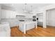 A modern white kitchen featuring an island, stainless steel appliances, and marble countertops and backsplash at 9799 Covent Garden Dr, Orlando, FL 32827