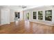 Bright living area with wood floors, multiple windows, and access to a balcony overlooking the outdoor scenery at 9799 Covent Garden Dr, Orlando, FL 32827