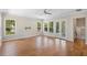 Bright living room featuring wood floors, large windows, a ceiling fan, and access to an outdoor balcony at 9799 Covent Garden Dr, Orlando, FL 32827