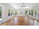 Light-filled living room featuring beautiful hardwood floors, high ceilings, a ceiling fan, and multiple windows at 9799 Covent Garden Dr, Orlando, FL 32827