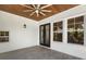 Spacious tiled porch with a wood ceiling, black-framed windows and french doors to the home's interior at 9799 Covent Garden Dr, Orlando, FL 32827