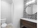 Stylish powder room featuring designer wallpaper, a wood vanity, and a circular mirror at 9799 Covent Garden Dr, Orlando, FL 32827