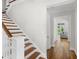 Staircase with wood treads leading to a hallway with a glimpse of the bright living room at 9799 Covent Garden Dr, Orlando, FL 32827