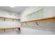 Spacious walk-in closet with adjustable wooden shelving and a window for natural light at 9799 Covent Garden Dr, Orlando, FL 32827