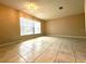 Bright living room with natural light from large window, tile flooring and neutral paint at 1001 Plantation Dr # E1, Kissimmee, FL 34741