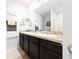 Bathroom with a double-sink vanity, granite countertops, and ample storage in the dark cabinets at 1015 Andean Ln, Davenport, FL 33837