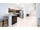 A spacious kitchen with dark cabinets, stainless steel appliances, and a breakfast bar for casual dining at 1015 Andean Ln, Davenport, FL 33837