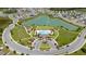 Aerial view featuring the community pool, playground, common areas, and a picturesque pond at 1015 Andean Ln, Davenport, FL 33837