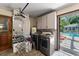 Laundry room with stainless steel appliances, white cabinets, and an open doorway to the pool at 1096 Dyson Dr, Winter Springs, FL 32708