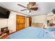 This main bedroom offers a unique ceiling fan, an entertainment center, and warm accents at 1096 Dyson Dr, Winter Springs, FL 32708