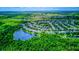 Overhead angle of a vibrant community nestled around a serene lake, enveloped by verdant green foliage at 12715 Moss Park Ridge Dr, Orlando, FL 32832