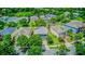 Real estate aerial view of home in a residential area with manicured lawns and mature trees at 12715 Moss Park Ridge Dr, Orlando, FL 32832