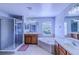 This bathroom features double sinks, a soaking tub, and a glass-enclosed shower, perfect for relaxing at 12715 Moss Park Ridge Dr, Orlando, FL 32832