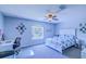 Bright bedroom features a desk, decorative wall art, and a large window with a view of the neighborhood at 12715 Moss Park Ridge Dr, Orlando, FL 32832