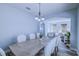 Inviting dining room with a modern chandelier, neutral decor, and an open view to the living room at 12715 Moss Park Ridge Dr, Orlando, FL 32832