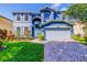 Beautiful two-story home with a well-maintained lawn, landscaped flowerbeds, and a brick driveway at 12715 Moss Park Ridge Dr, Orlando, FL 32832