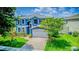 Lovely two-story home with a well-manicured lawn, lush landscaping, and a brick driveway at 12715 Moss Park Ridge Dr, Orlando, FL 32832