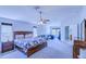 Spacious main bedroom features a ceiling fan, an ensuite bathroom, a sitting area, and a workspace at 12715 Moss Park Ridge Dr, Orlando, FL 32832