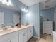 Bright bathroom featuring double sinks, a large mirror, and a separate shower at 1278 Asher Mason Ave, Kissimmee, FL 34744