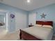 Comfortable bedroom featuring a wood-framed bed with neutral bedding, closet, and bright natural light at 1278 Asher Mason Ave, Kissimmee, FL 34744