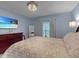 A lovely bedroom with bright blue walls, carpet, tv, and natural light at 1278 Asher Mason Ave, Kissimmee, FL 34744