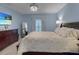 Cozy bedroom with blue walls, dresser, tv, plush bedding, and natural light at 1278 Asher Mason Ave, Kissimmee, FL 34744
