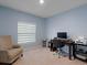 Comfortable bedroom with a window, accent chair and dark wood desk at 1278 Asher Mason Ave, Kissimmee, FL 34744