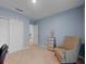 Cozy bedroom featuring a comfortable armchair, closet, and an open doorway to another room at 1278 Asher Mason Ave, Kissimmee, FL 34744