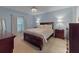 Comfortable bedroom features a wooden bed frame, carpet flooring, and simple decor at 1278 Asher Mason Ave, Kissimmee, FL 34744
