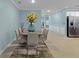 Well-lit dining room with elegant table, chairs, and decorative sunflower centerpiece atop a neutral-toned rug at 1278 Asher Mason Ave, Kissimmee, FL 34744