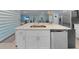 Modern kitchen island featuring a stainless steel dishwasher and sink with white cabinets at 1278 Asher Mason Ave, Kissimmee, FL 34744