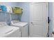 Functional laundry room with washer, dryer, shelving, and storage space at 1278 Asher Mason Ave, Kissimmee, FL 34744