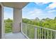 Balcony view showcasing lush greenery and a glimpse of the lake at 13415 Blue Heron Beach Dr # 401, Orlando, FL 32821