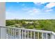 Balcony view overlooking lush landscaping, parking area, and cityscape in the distance at 13415 Blue Heron Beach Dr # 401, Orlando, FL 32821