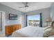 Comfortable bedroom featuring a large window, ceiling fan, and stylish furnishings at 13415 Blue Heron Beach Dr # 401, Orlando, FL 32821