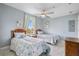 Serene bedroom with two twin beds, ceiling fan, and a bright window offering a pleasant view at 13415 Blue Heron Beach Dr # 401, Orlando, FL 32821